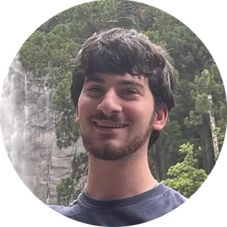 Aaron L. Schlossberg at Nachi Falls in Nachikatsuura, Wakayama Prefecture, Japan, smiling in front of a waterfall